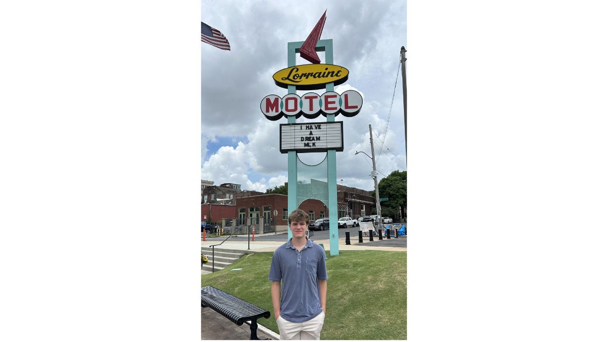 Carter standing in front of the Lorraine Motel sign reading 'I Have a Dream: MLK'