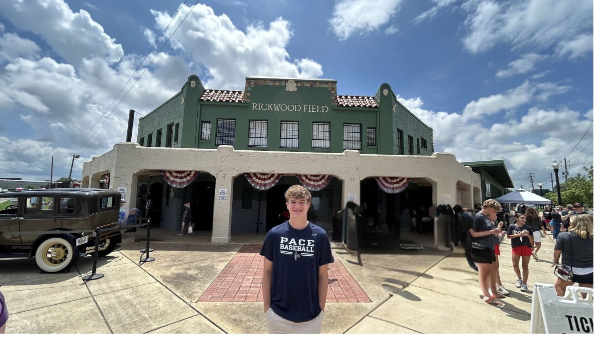 Rickwood Field facade: green building, bunting on the arches, vintage car to the left